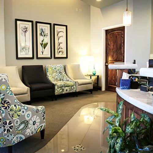 Modern dental office waiting room with comfortable seating, plants, and welcoming décor.