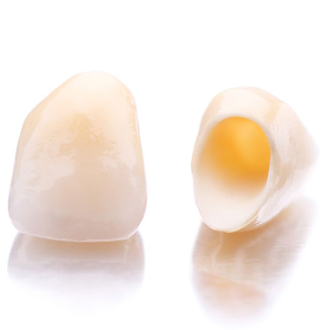 Whole and halved boiled eggs displayed against white background with reflections.